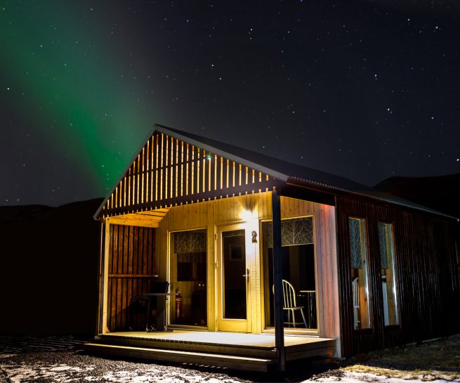 cottage house at the night with northern lights for rent
